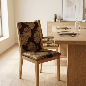 Ekskluzywny materiał obiciowy Diva z bogatym, błyszczącym złotym ornamentem na ciemnym tle aranżacja krzesło