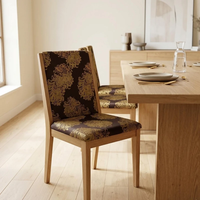 Ekskluzywny materiał obiciowy Diva z bogatym, błyszczącym złotym ornamentem na ciemnym tle aranżacja krzesło