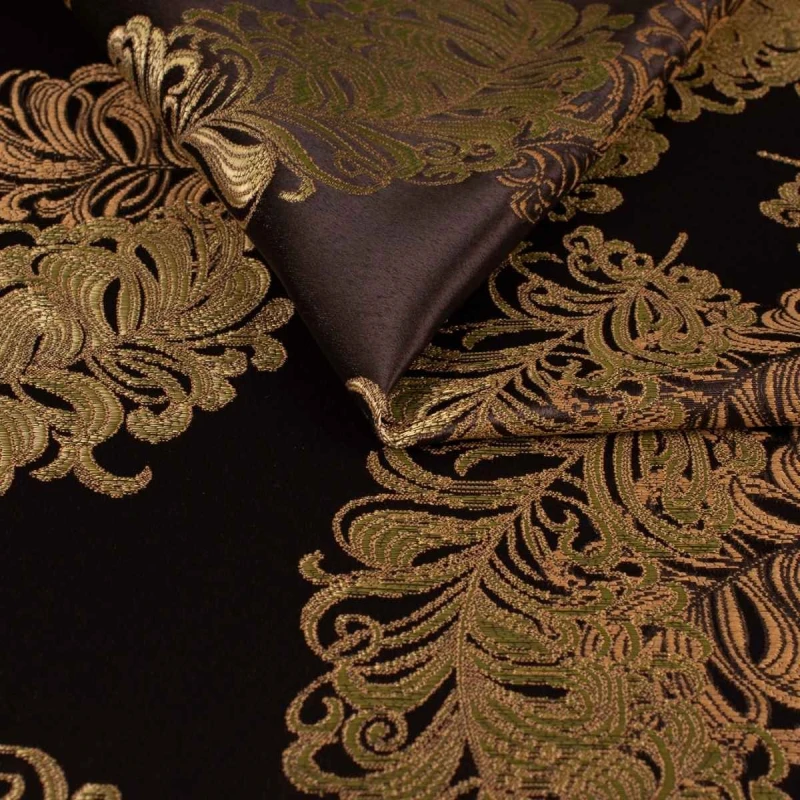 Ekskluzywny materiał obiciowy Diva z bogatym, błyszczącym złotym ornamentem na ciemnym tle