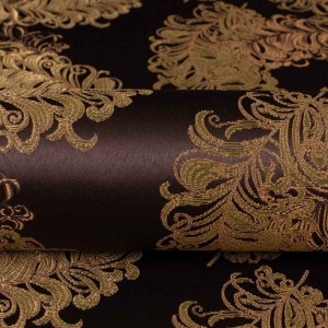 Ekskluzywny materiał obiciowy Diva z bogatym, błyszczącym złotym ornamentem na ciemnym tle