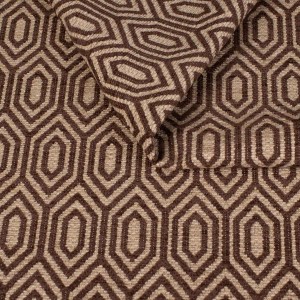 Zbliżenie na strukturę tkaniny tapicerskiej o wzorze geometrycznym. Brązowe, kontrastowe linie tworzą wzór wydłużonych sześciokątów (heksagonów) na beżowym, melanżowym tle.