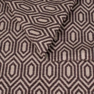 Zbliżenie na strukturę tkaniny tapicerskiej o wzorze geometrycznym. Ciemnografitowe, kontrastowe linie tworzą wzór wydłużonych sześciokątów (heksagonów) na jasnoszarym, melanżowym tle.