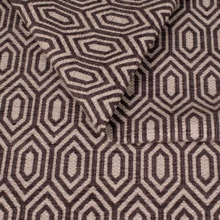 Zbliżenie na strukturę tkaniny tapicerskiej o wzorze geometrycznym. Ciemnografitowe, kontrastowe linie tworzą wzór wydłużonych sześciokątów (heksagonów) na jasnoszarym, melanżowym tle.