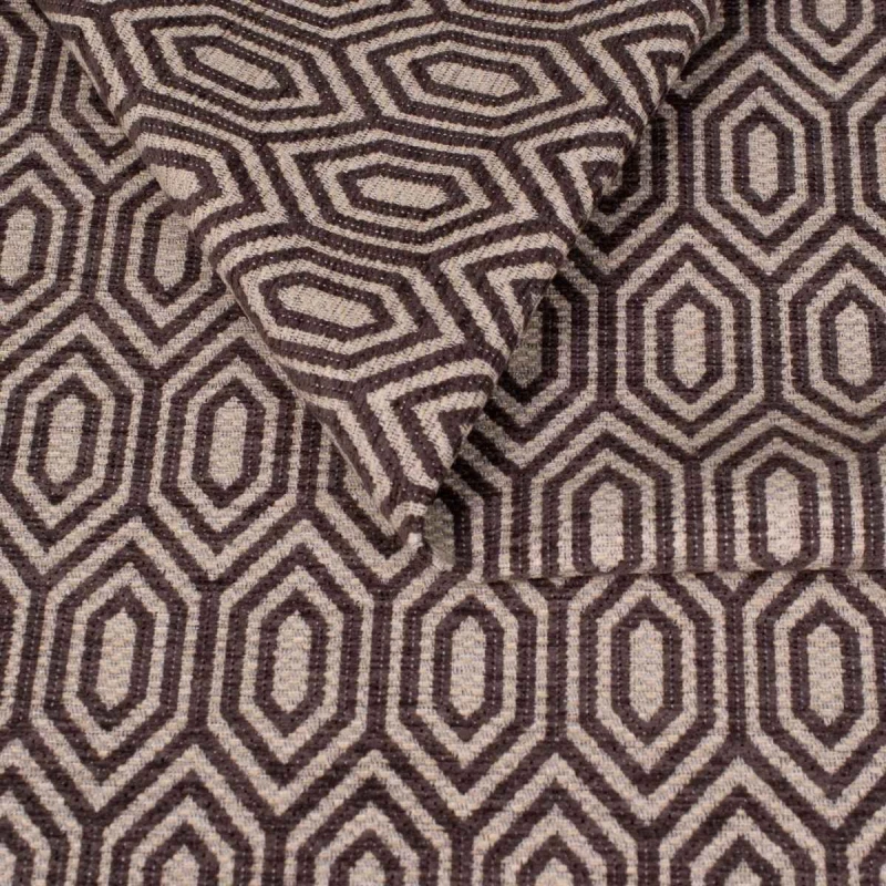 Zbliżenie na strukturę tkaniny tapicerskiej o wzorze geometrycznym. Ciemnografitowe, kontrastowe linie tworzą wzór wydłużonych sześciokątów (heksagonów) na jasnoszarym, melanżowym tle.